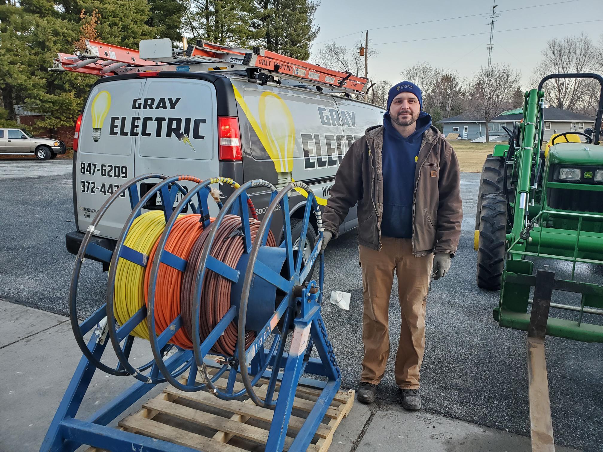 A Gray Electric technician with a service van