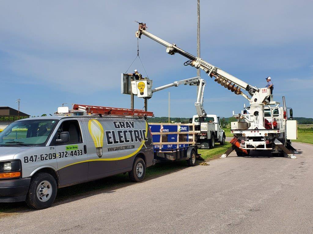 Gray Electric crews setting utility poles with bucket trucks