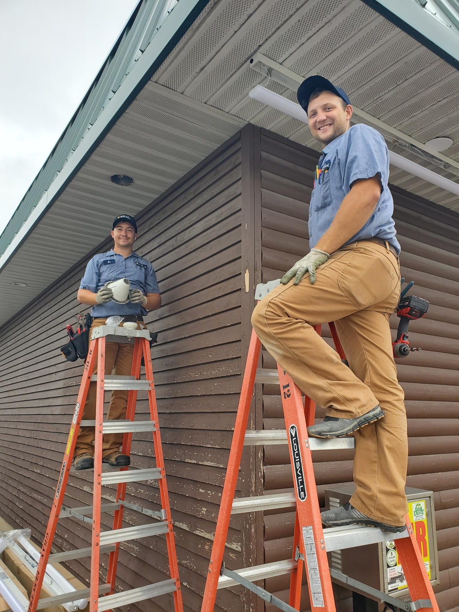 Two Gray Electric technicians working on a residential ceiling