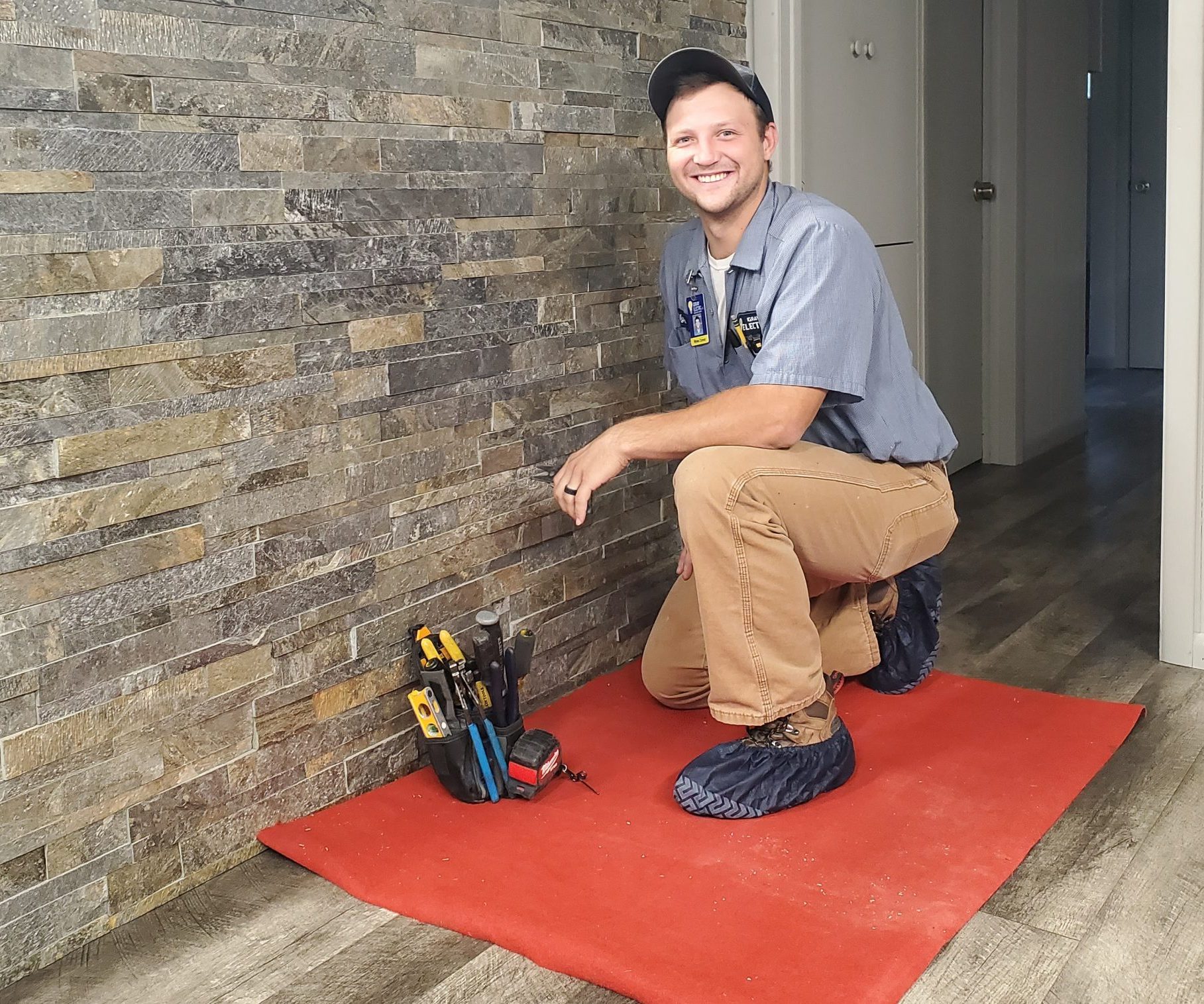 A Gray Electric technician working carefully on a residential installation